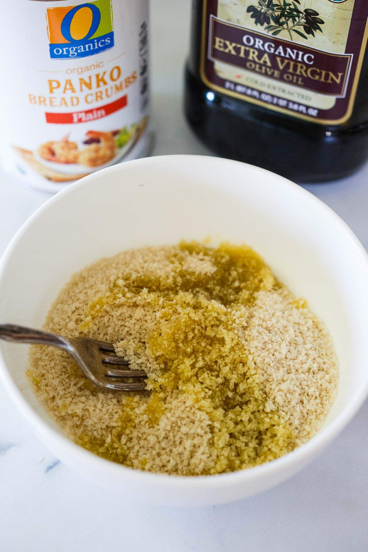 small bowl with panko breadcrumbs and oil, mixed with fork.