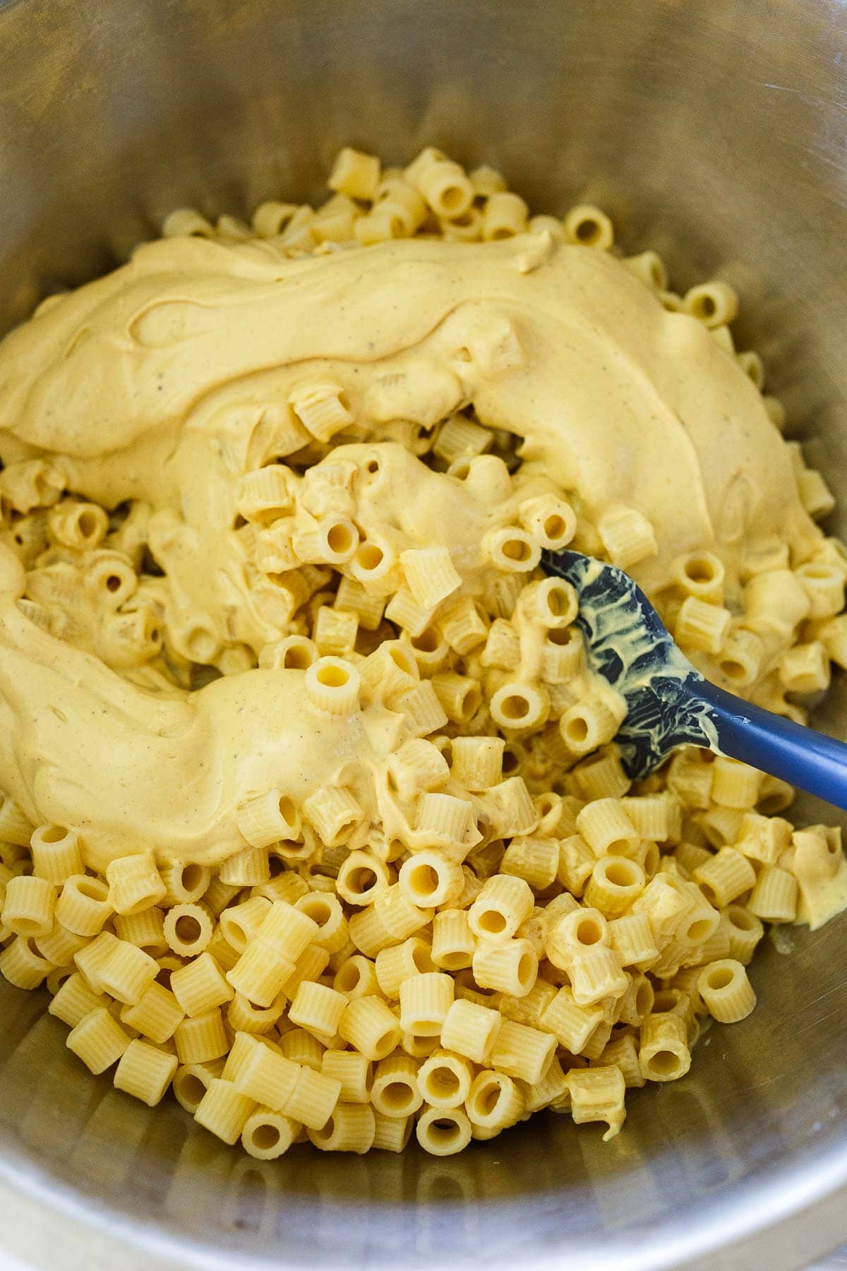 large pot with cooked ditalini noodles and creamy vegan mac and cheese sauce.