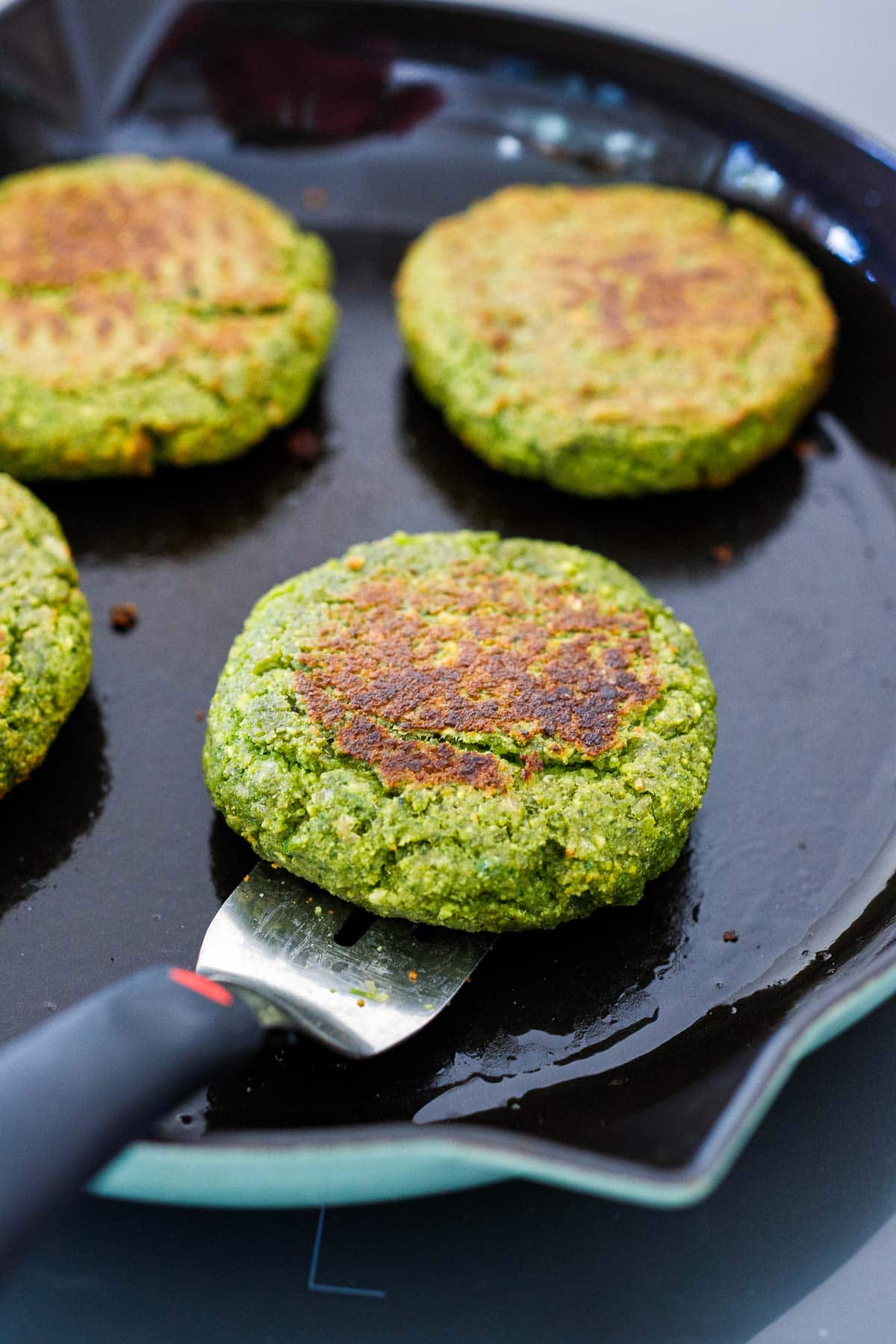 falafel burgers pan-searing in cast iron skillet.