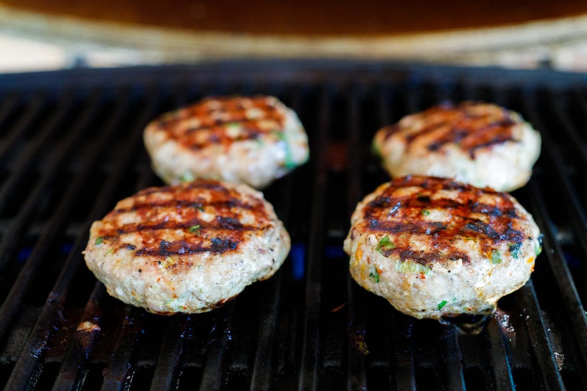 golden turkey burgers on a grill. 