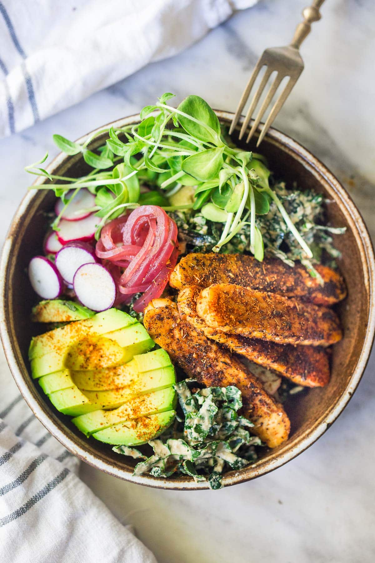  tempeh salad in a bowl with a fork. 