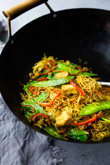 Vegetarian Singapore Noodles in a wok with veggies and tofu.