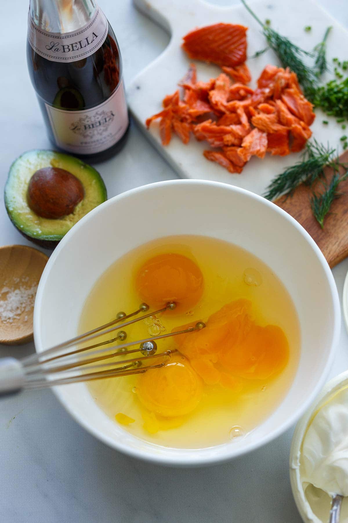 bowl with egg yolks and whites with whisk.