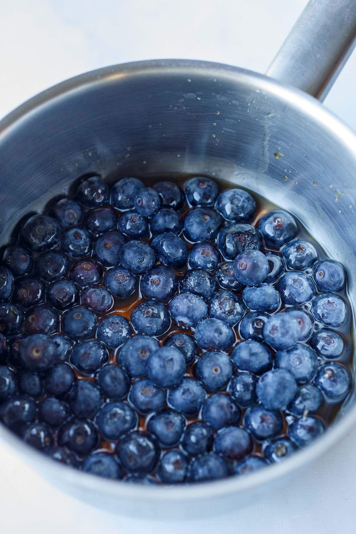 fresh blueberries in pot with maple syrup.