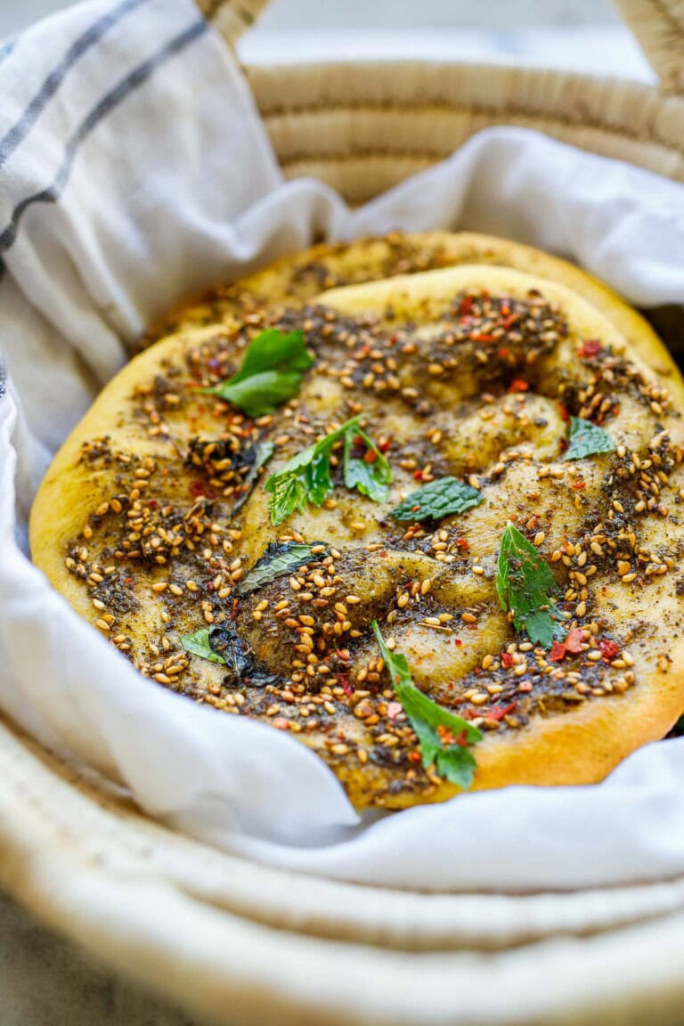 Tender Lebanese flatbread called manoushe is slathered with a mixture of zaatar spice and olive oil, a delicious appetizer or breakfast on the go. Vegan & gluten-free adaptable.