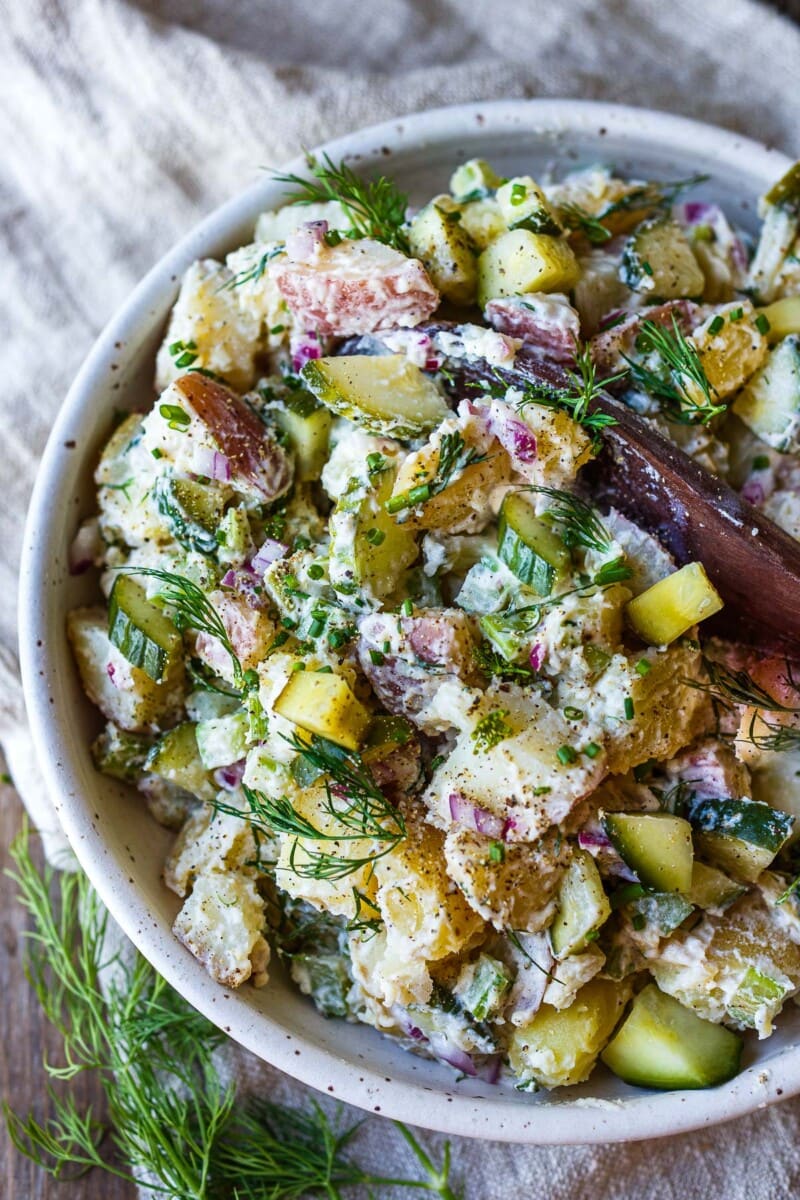 This creamy potato salad recipe is deliciously light and tangy, the perfect side dish for summer BBQs! Made with quick pickled cucumbers, fresh dill, and a lightened-up yogurt dressing. Vegan-adaptable & gluten-free.